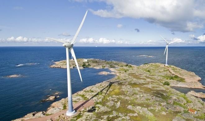 Två vindkraftverk på berget vid havet.