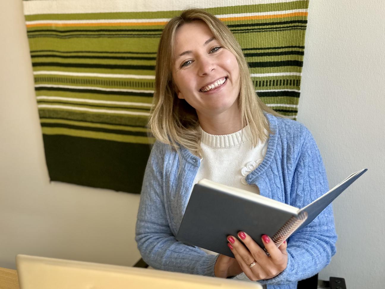 Glad kvinna med en bok i handen