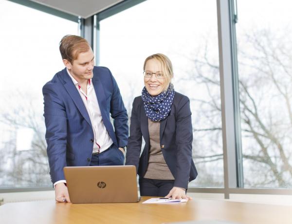 Två personer vid en dator i konferensrum